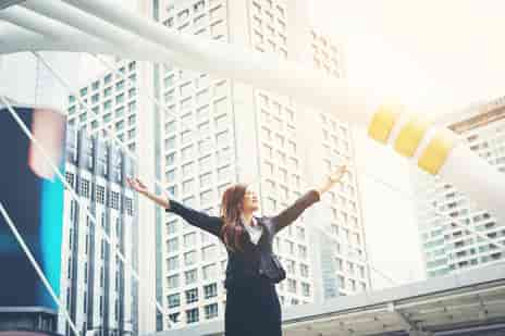 Image of a woman with her arms in the arm celebrating -- My journey to becoming a certified life coach